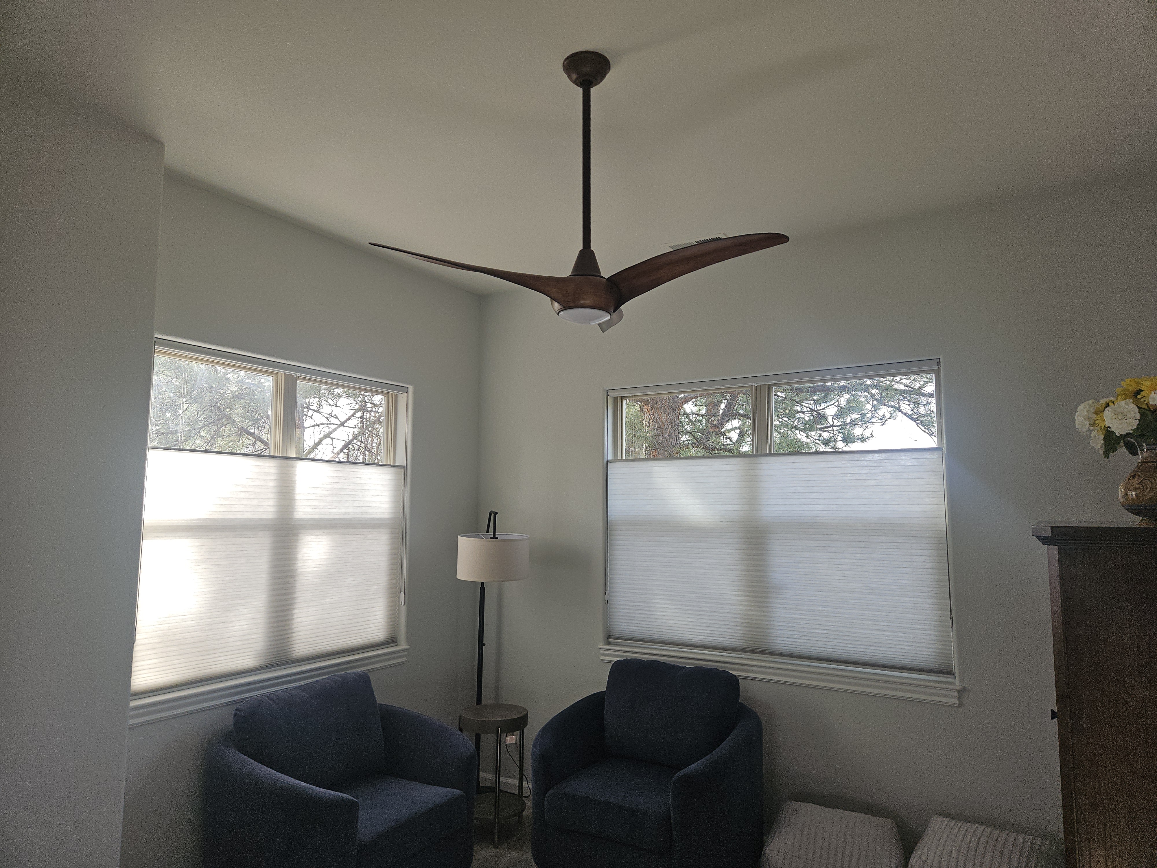 Bedroom with a newly installed ceiling fan above two blue accent chairs