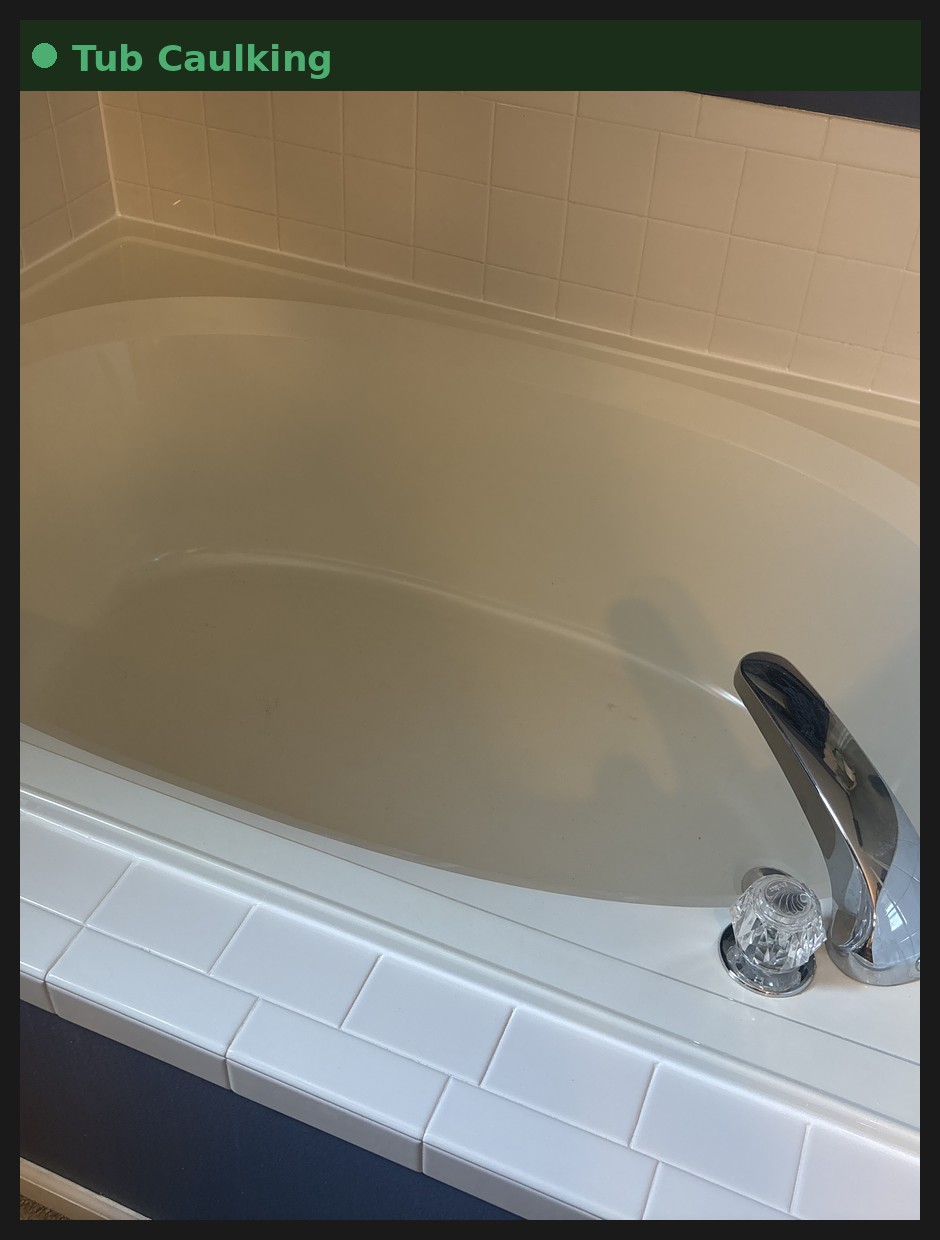 Freshly re-caulked bathtub corner as part of home maintenance