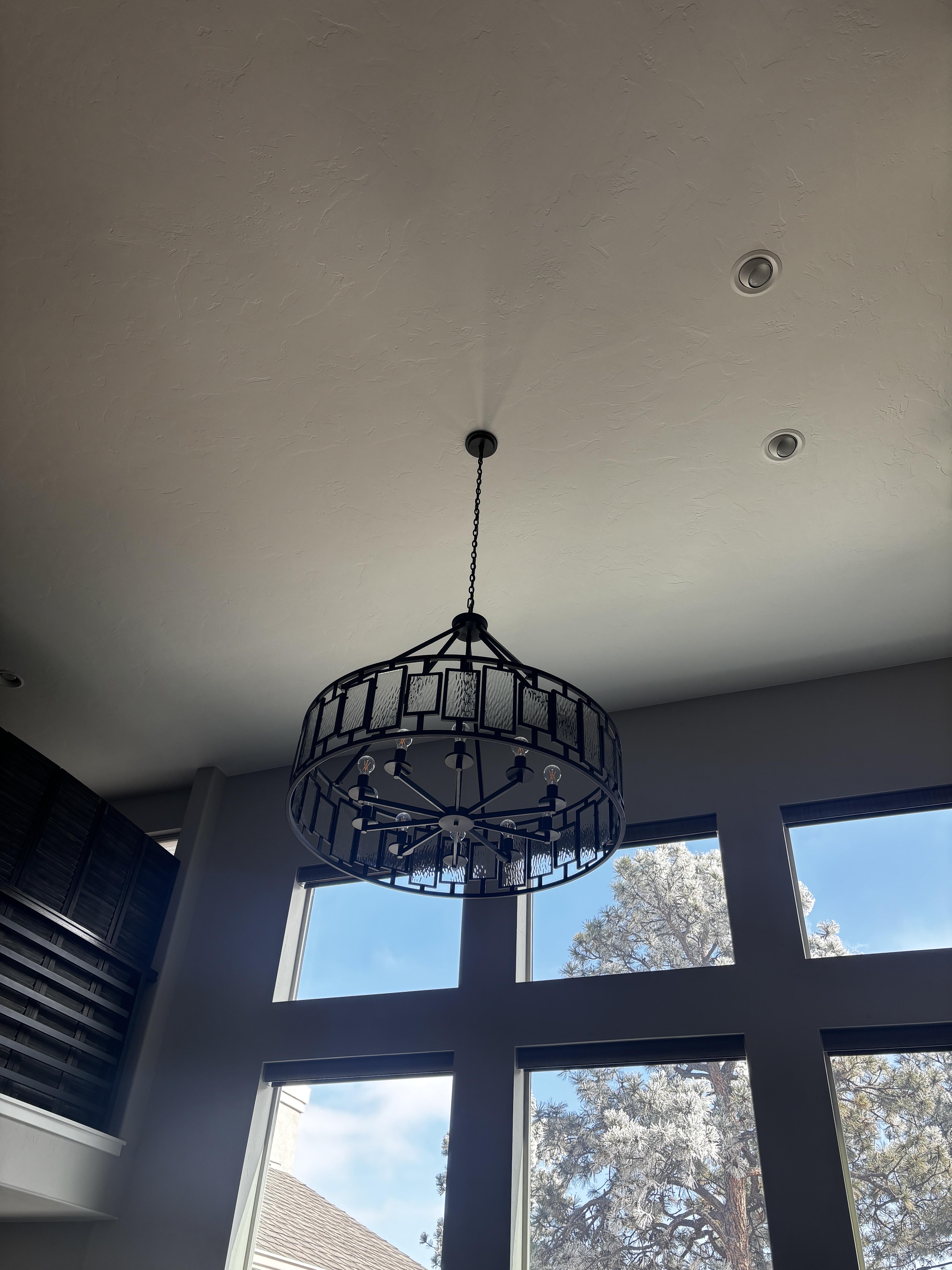 Black cage-style pendant chandelier installed in a vaulted-ceiling
