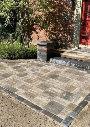 Custom brick paver walkway and entryway installation for a residential home, featuring steps and decorative pillars by The Guy Outdoor Services.