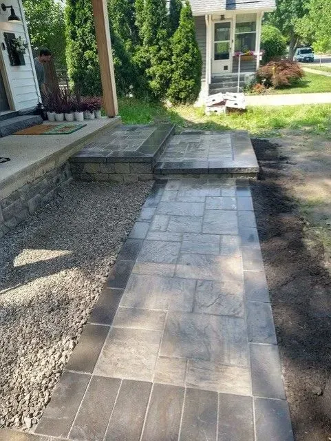 Paver walkway and steps for a residential hardscape entrance, featuring gray-toned pavers and stone block steps.