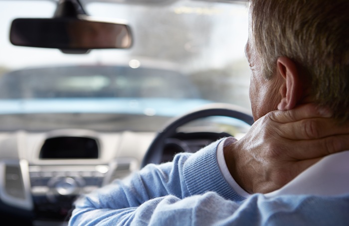 man in the car with Whiplash Pain