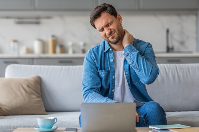 Man in house feeling neck pain