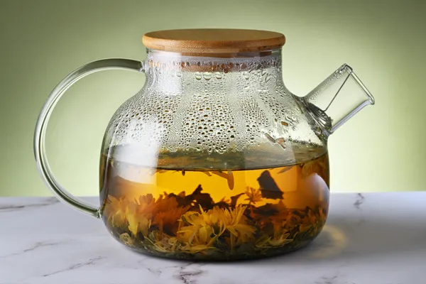 Glass jar of herbal tea infusion with fresh herbs for a nourishing herbal drink