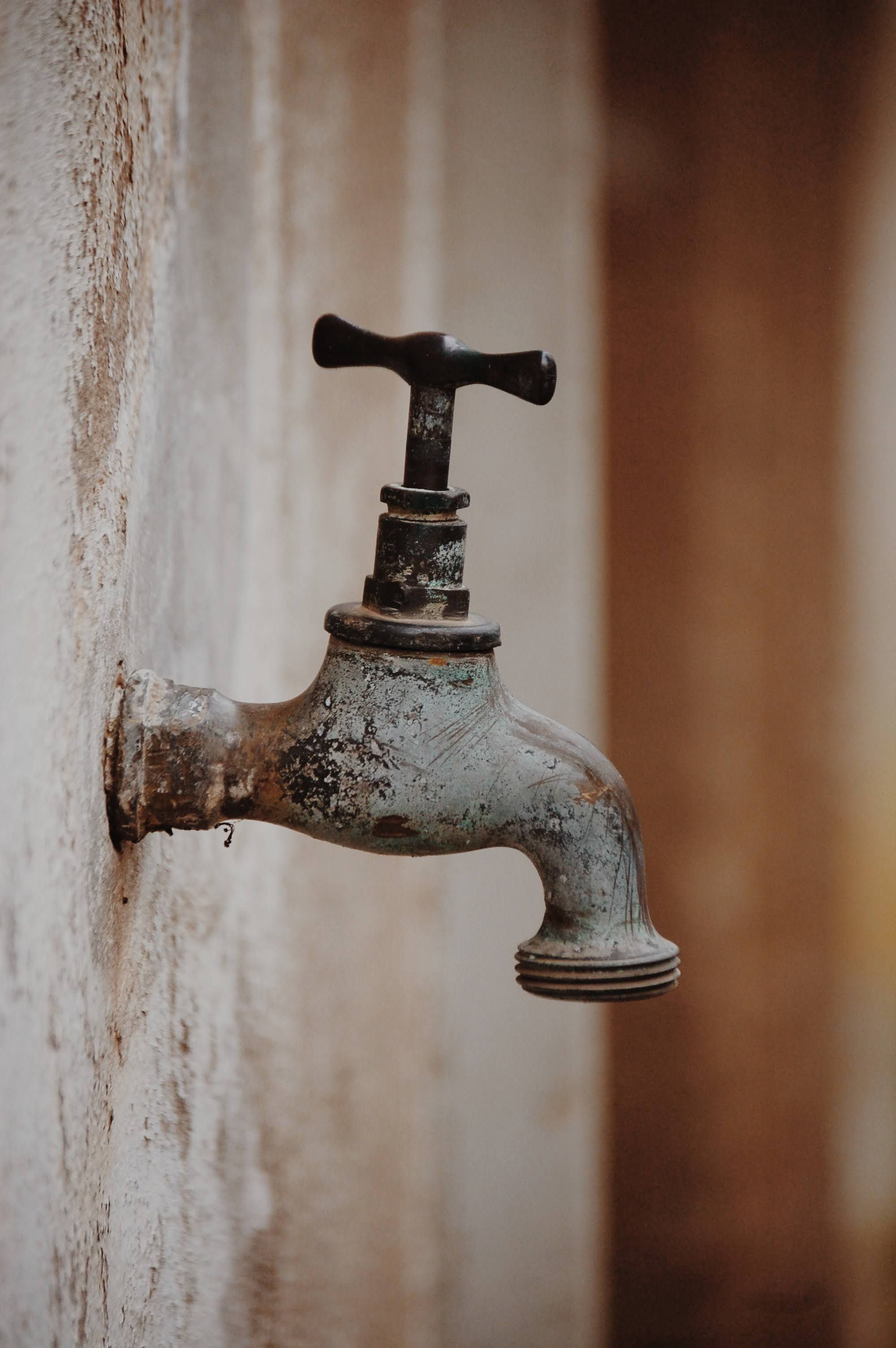 Glass of tap water being filled from a kitchen faucet
