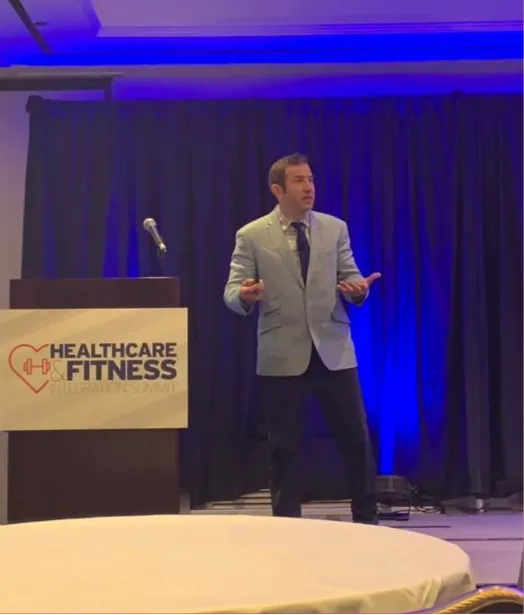 Speaker on stage at healthcare fitness event