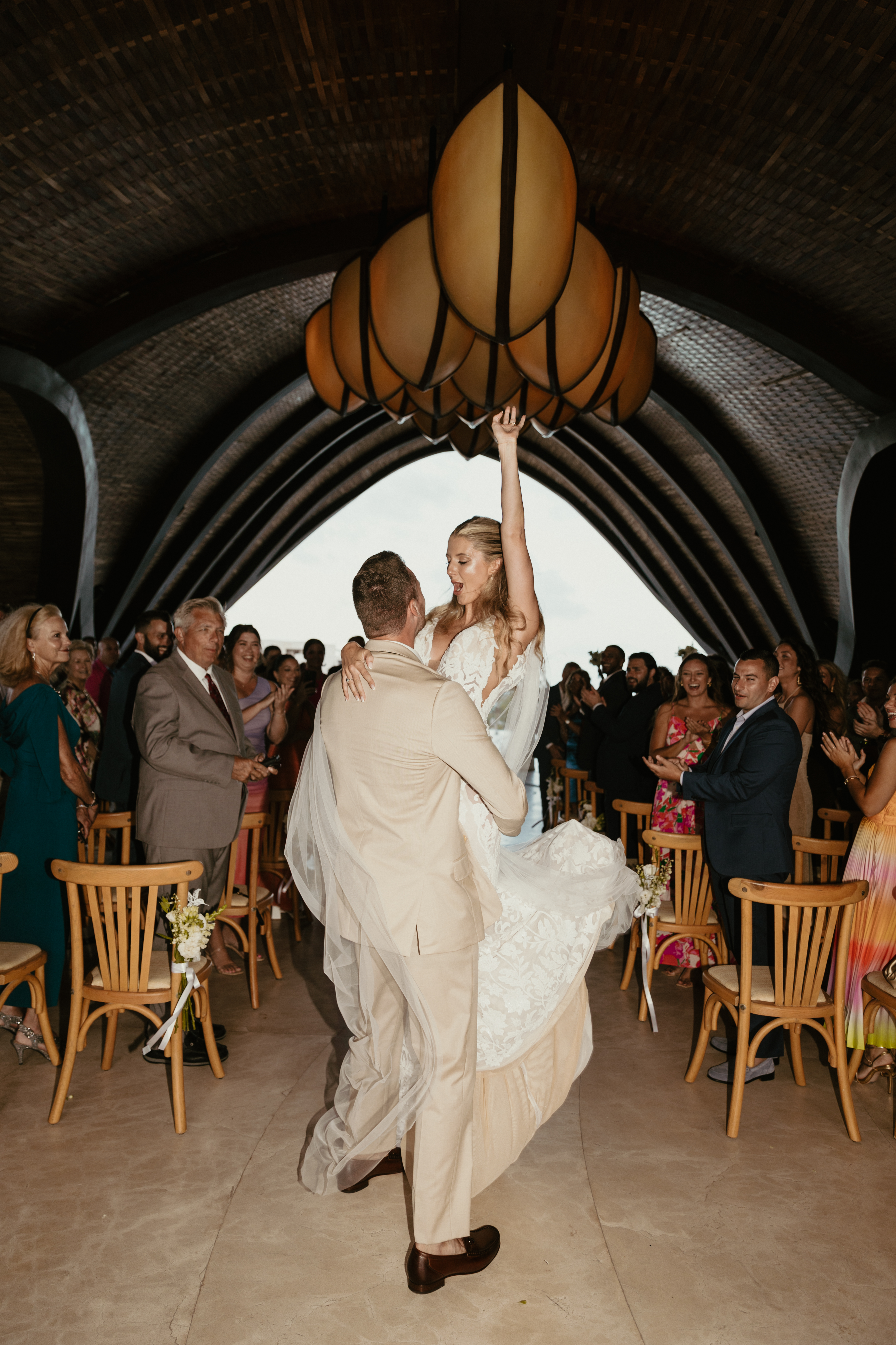 Bride in white dress on beach with veil blowing