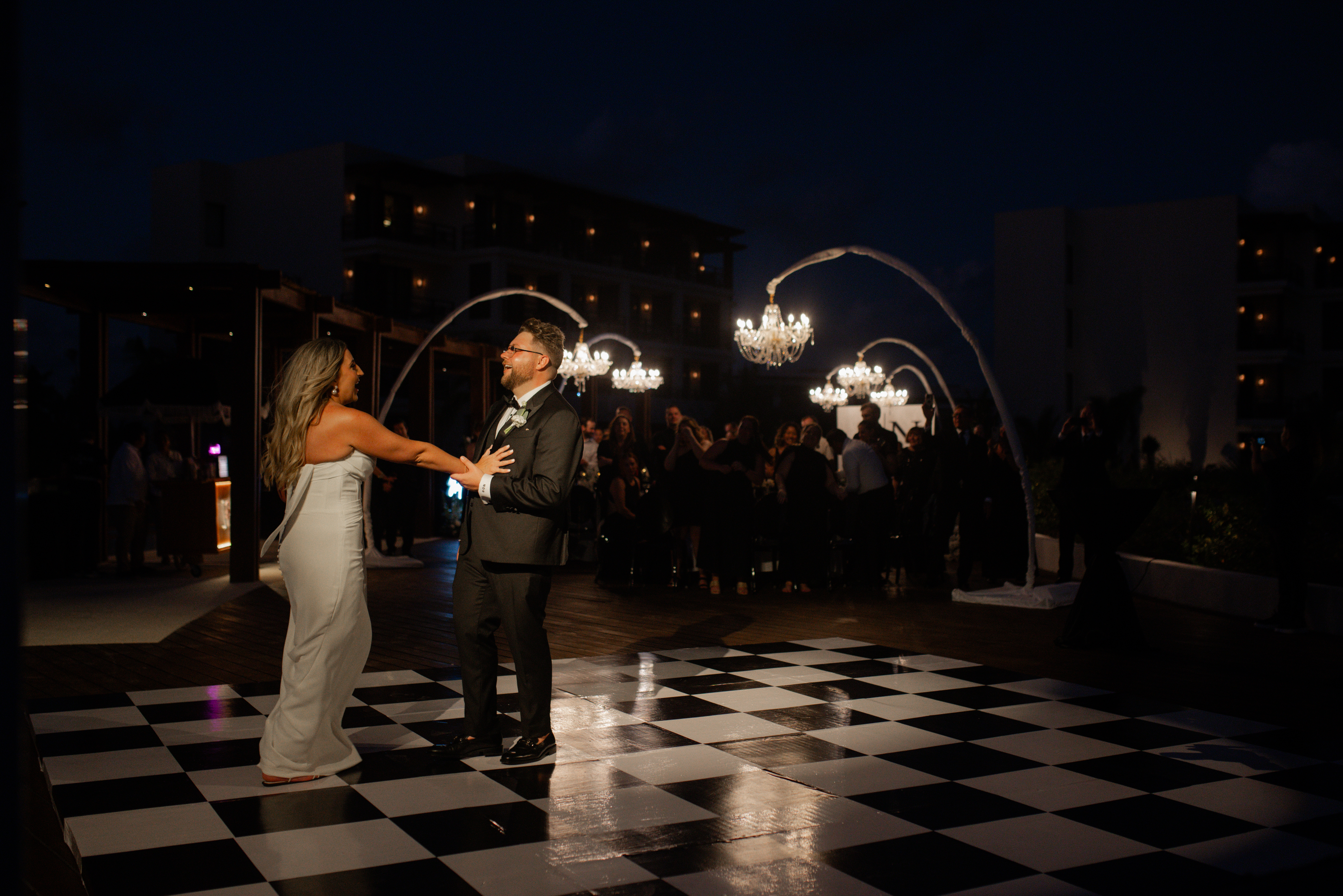 Couple embracing on a wet sandy beach.