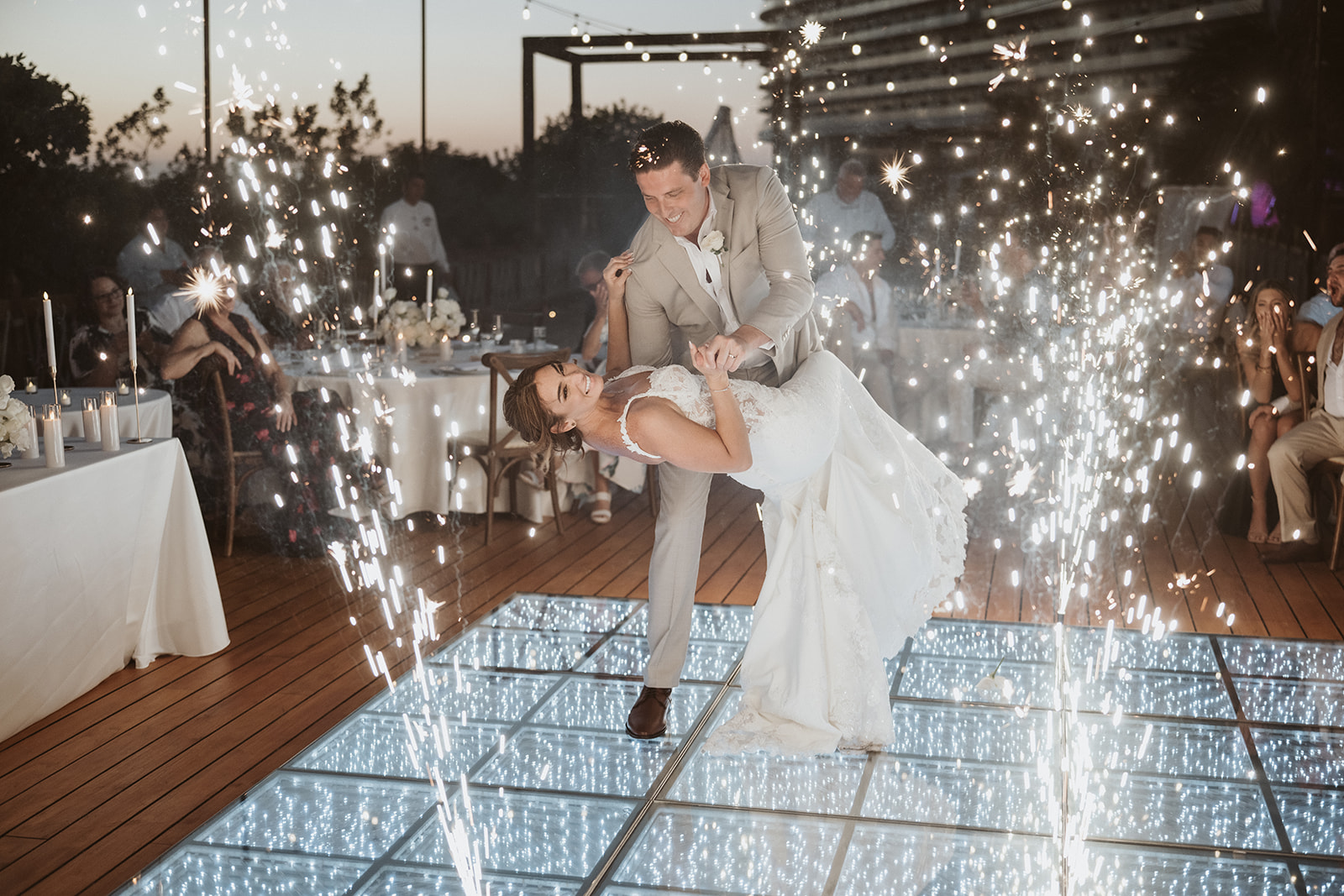 Couple embracing on a wet sandy beach.