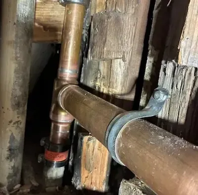 Corroded galvanized pipes inside wall cavity identified for replacement in Bexley home