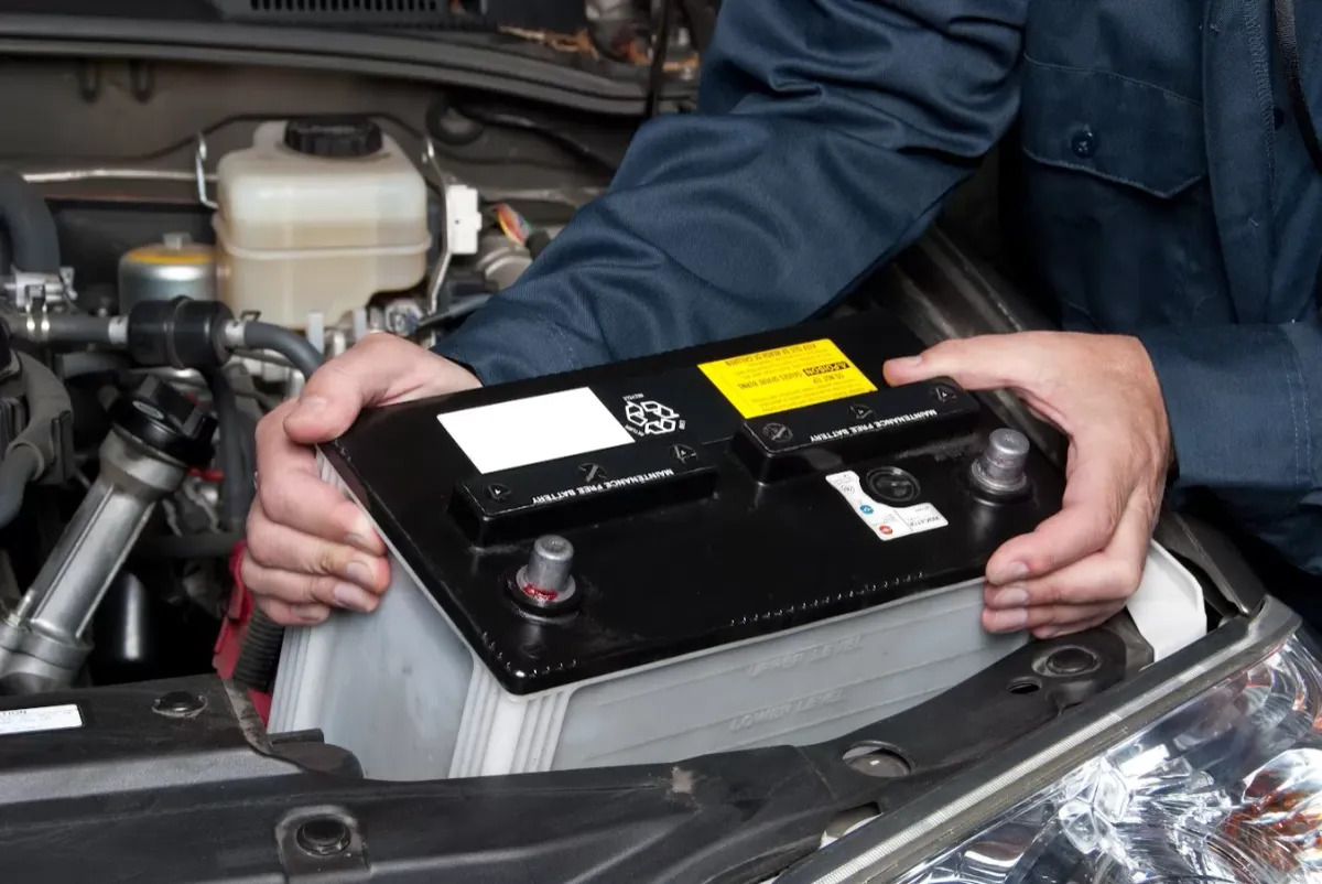 Automotive technician testing a car battery at an auto repair shop in Albuquerque, NM.