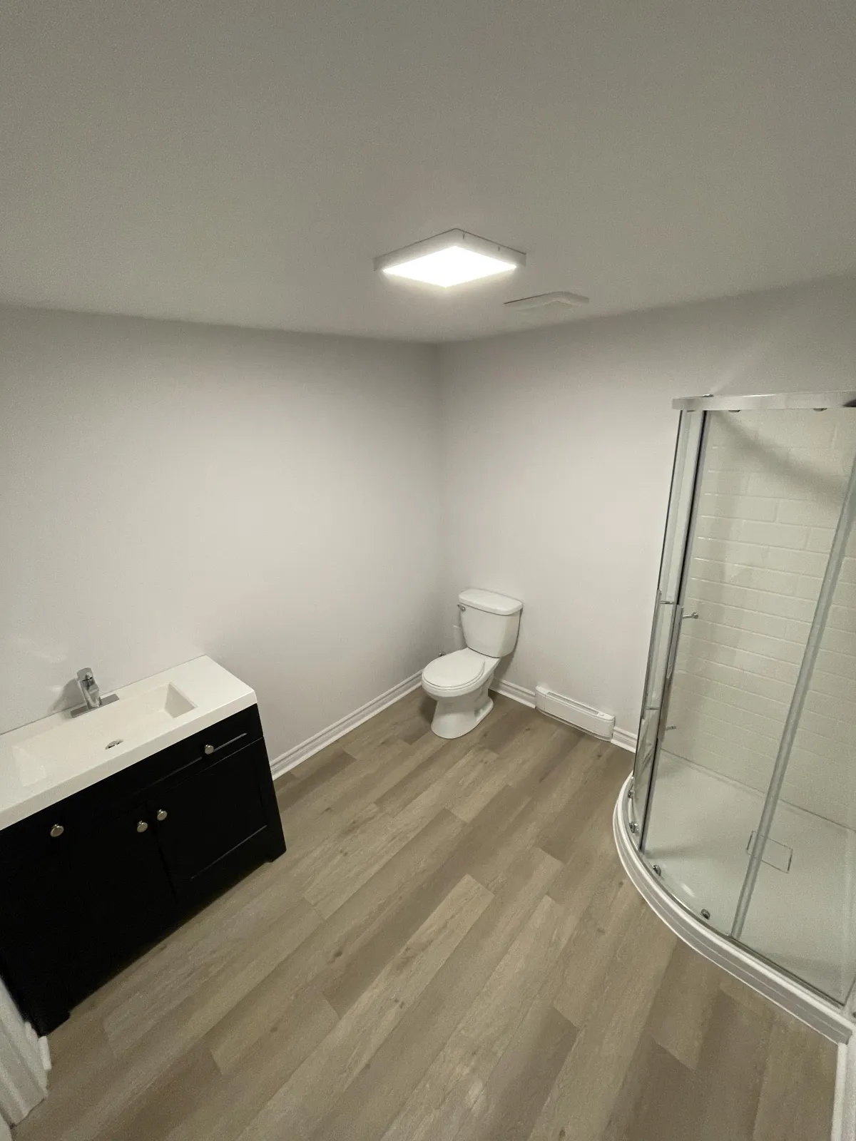 Photo avant/après d’une salle de bain montrant le carrelage, la douche et les finitions après rénovation.