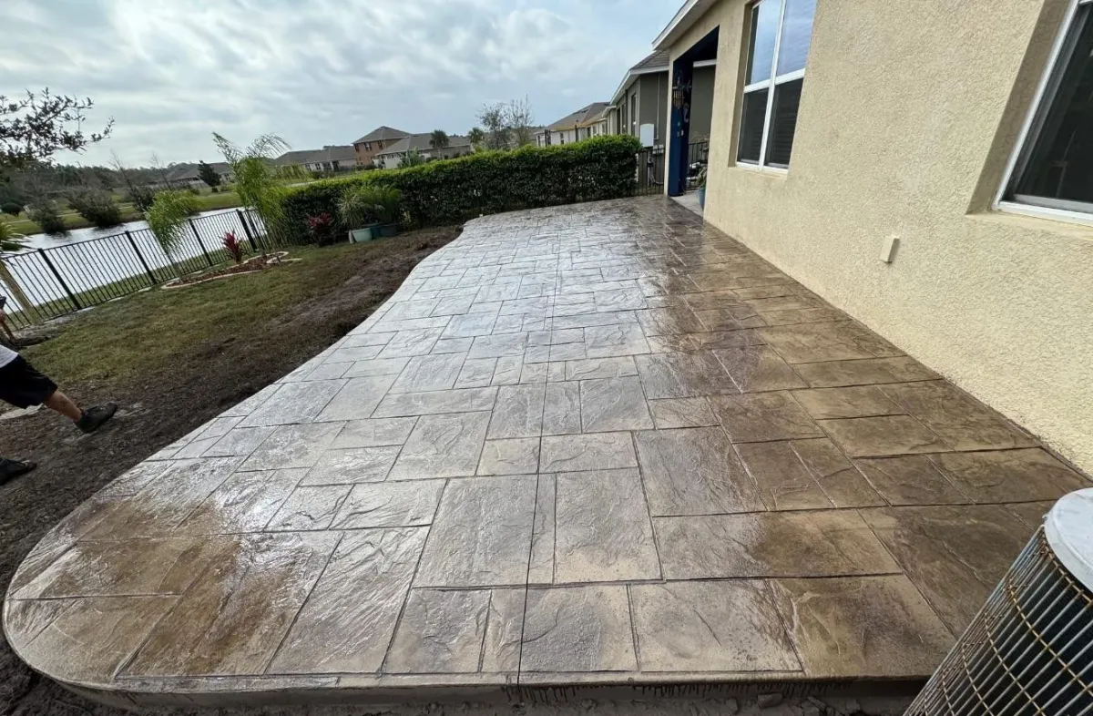 Custom concrete solutions icon featuring a combination of driveways, patios, walkways, stamped concrete, and foundation slabs in an orange color scheme. Perfect for decorative and specialty concrete projects.