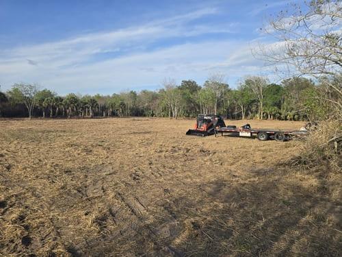 Kubota SVL 97-3 compact track loader and trailer on a freshly cleared job site by J.F. PRO SERVICES LLC in Orange City, FL.