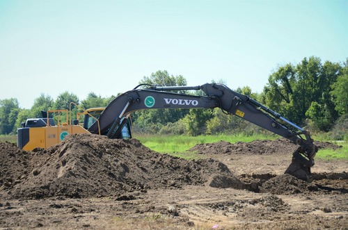 Excavator performing site grading and earthmoving on a land clearing project in Deltona, FL by J.F. PRO SERVICES LLC.