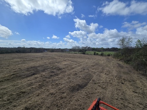 Cleared and graded lot ready for construction after site preparation by J.F. PRO SERVICES LLC in Deltona, FL with Kubota equipment visible on the property.