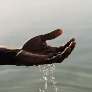 Hands holding and catching splashes of water, symbolizing renewal.