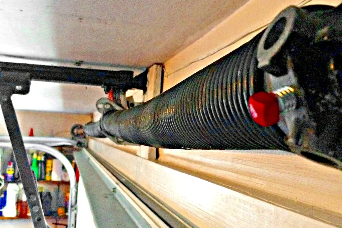 Technician replacing a broken garage door torsion spring in Chesapeake VA