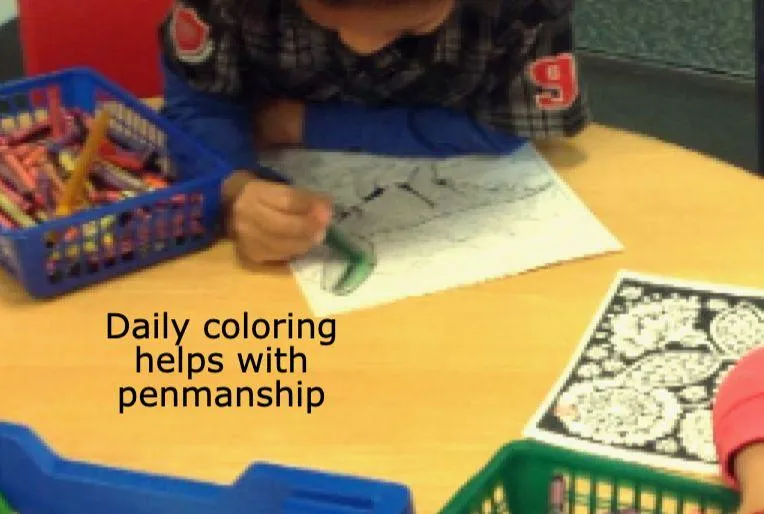 Child writes A in green sand