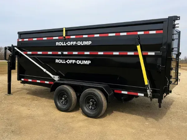  Two roll-off dumpsters stacked on a black tandem axle trailer secured with yellow straps on a dirt lot.
