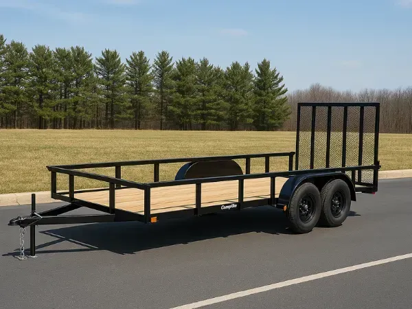 Open utility trailer with wooden deck and mesh ramp gate parked in an asphalt lot near grassy area.