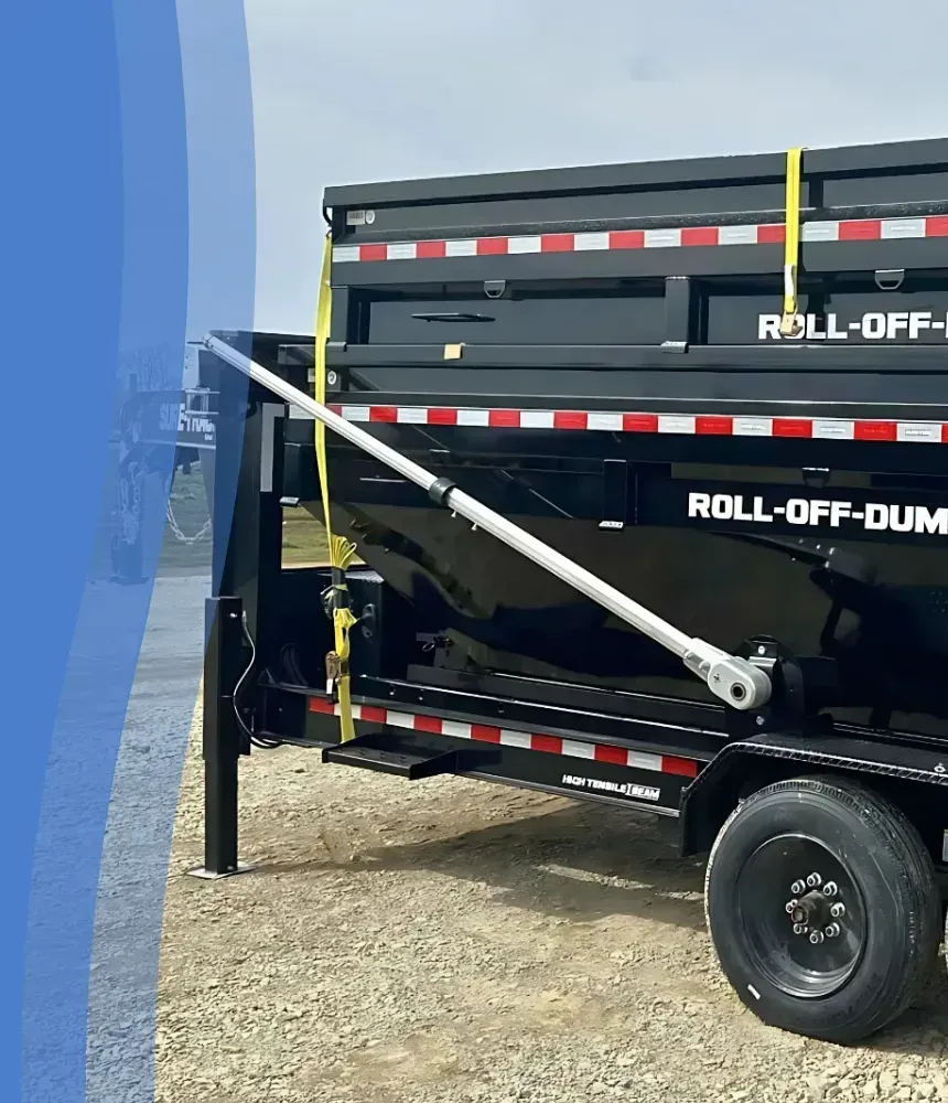 Dumpster Junkies roll-off dump trailer hitched to a white Ford pickup truck on a gravel lot.