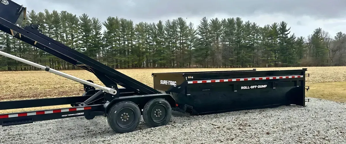 Utility trailer, black dump trailer, and white enclosed trailer side by side