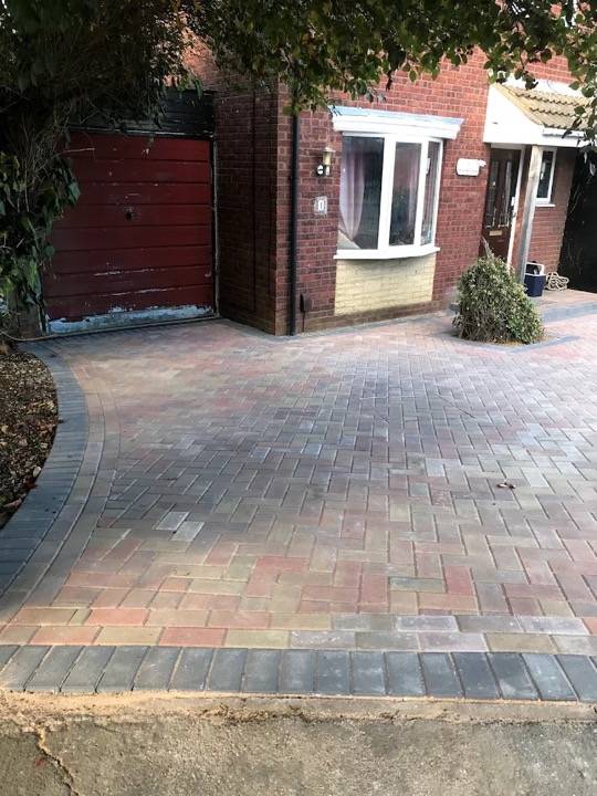 Block paved driveway in red and charcoal herringbone pattern