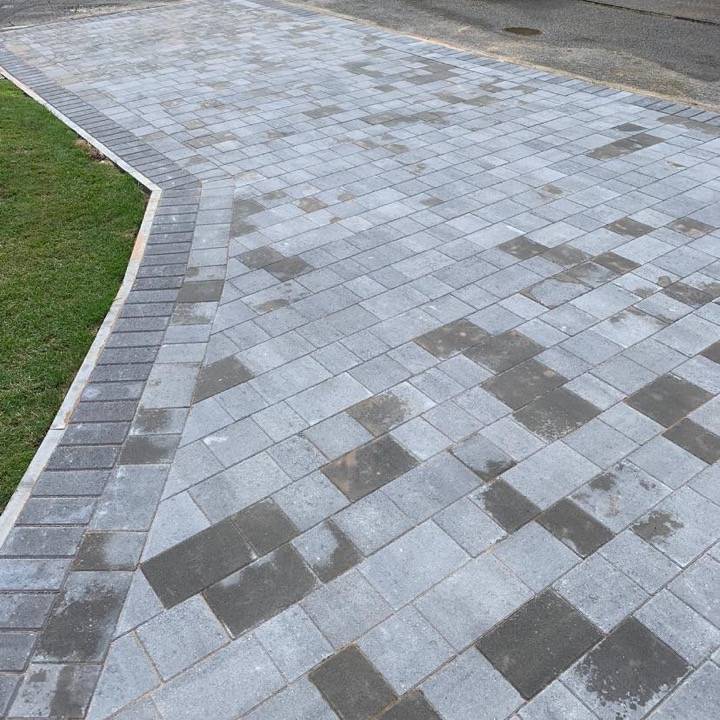 Silver and charcoal block paved driveway with curved edge and lawn strip