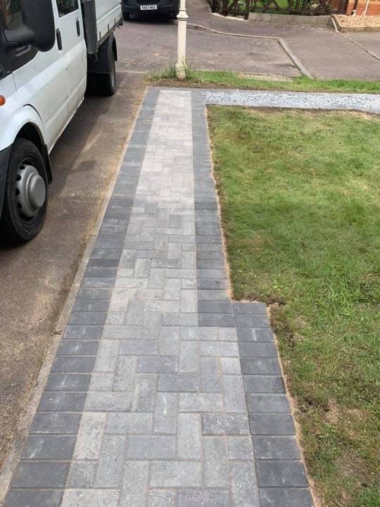 Block paved path edge detail showing charcoal and buff block pattern