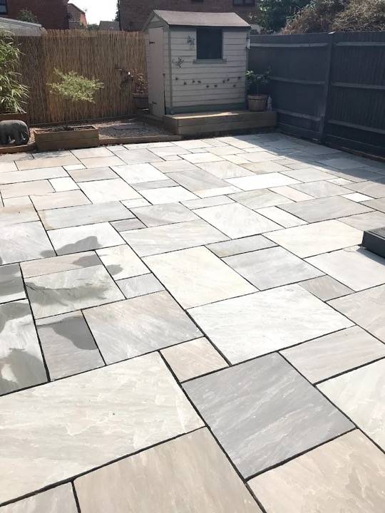Silver sandstone patio with sleeper borders in rear garden