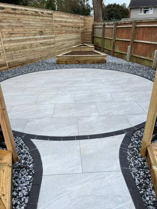 Oval patio with dark edging and gravel borders from above
