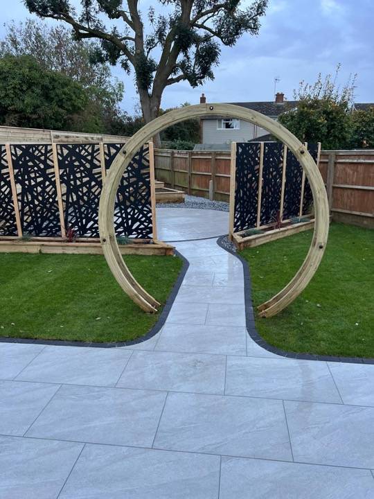 Moon gate arch with porcelain path leading through landscaped garden