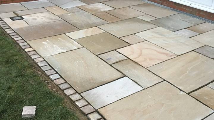 Indian sandstone patio with cobble edging installed in Hemel Hempstead