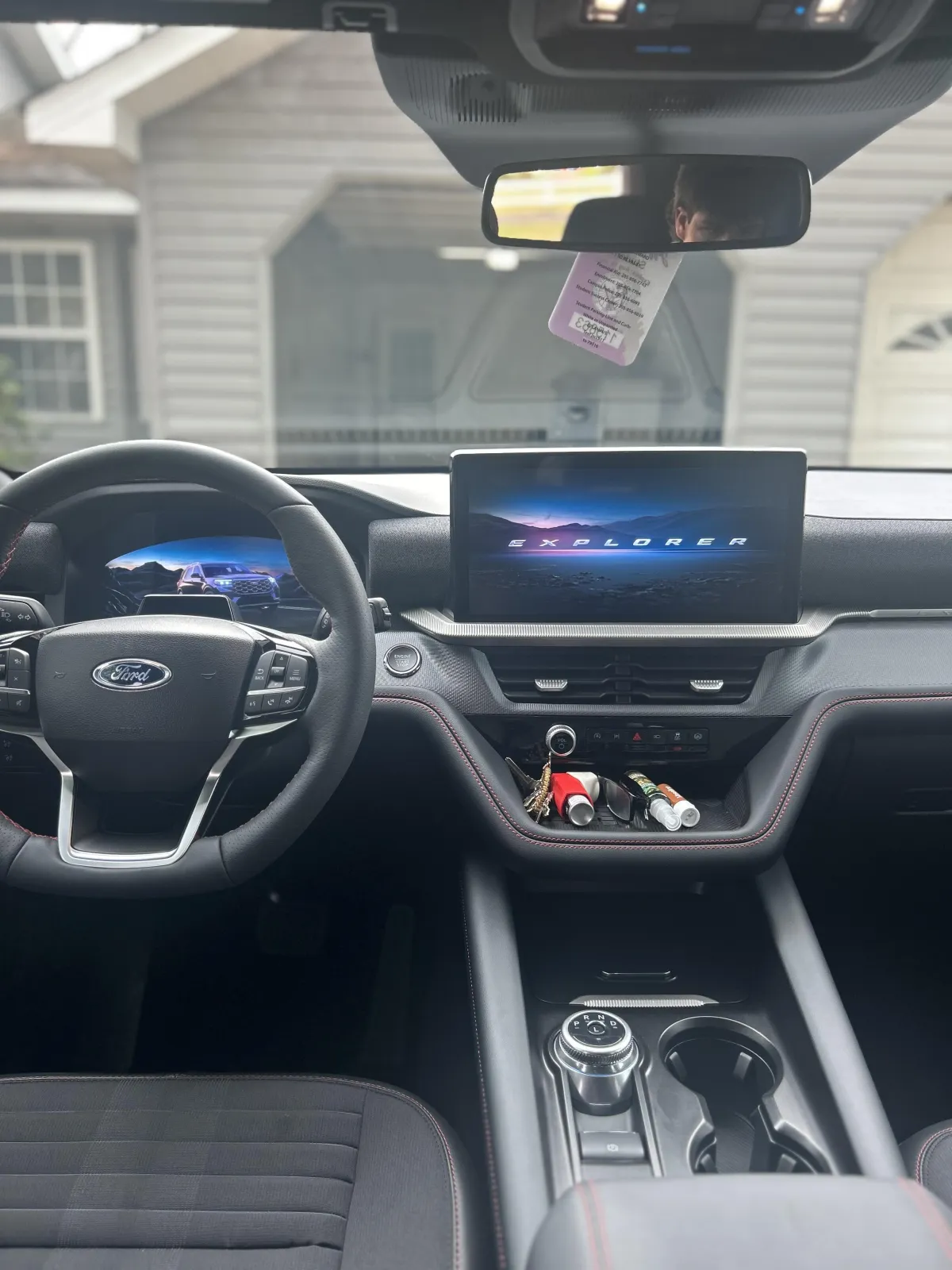 White Corvette with roof down and white Mercedes in the background