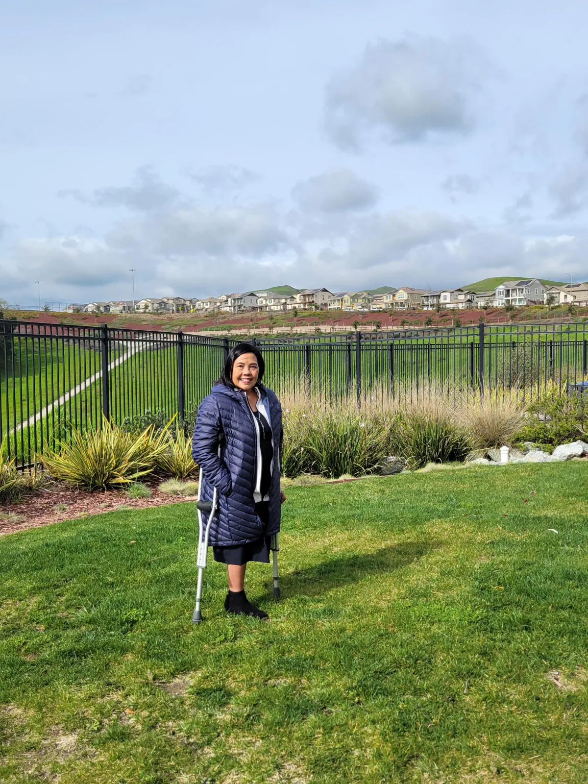 Vince Abramo standing with her crutches, reflecting on how falling, listening, and asking before helping have shaped her approach to communication and leadership.