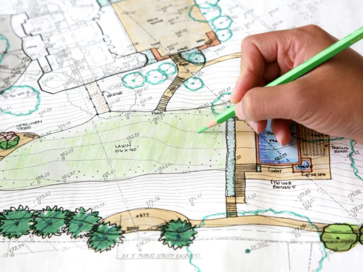 fields by duran: Landscape architect drawing and coloring a detailed backyard design plan with pool, lawn, and garden features.