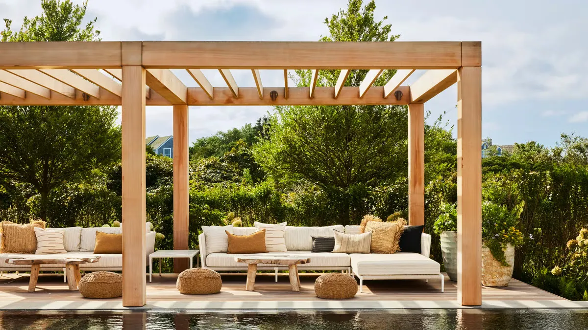 fields by duran: Modern outdoor patio with wooden pergola, comfortable lounge seating, neutral cushions, and garden greenery in the background.