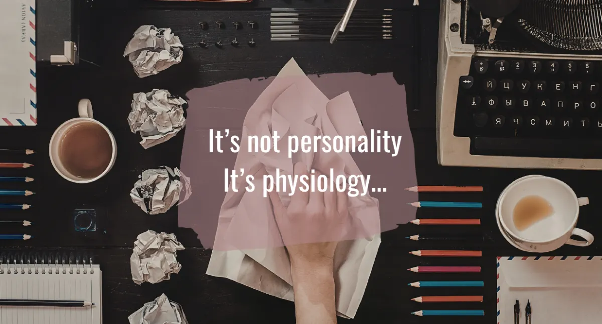 desktop with typewriter, pens and pencils organised into very straight lines, plus multiple crumpled up and discarded pages lined up in a neat row depicting rigid neatness and dissatisfaction with work. text on image reads 'it's not psychology. it's physiology'.