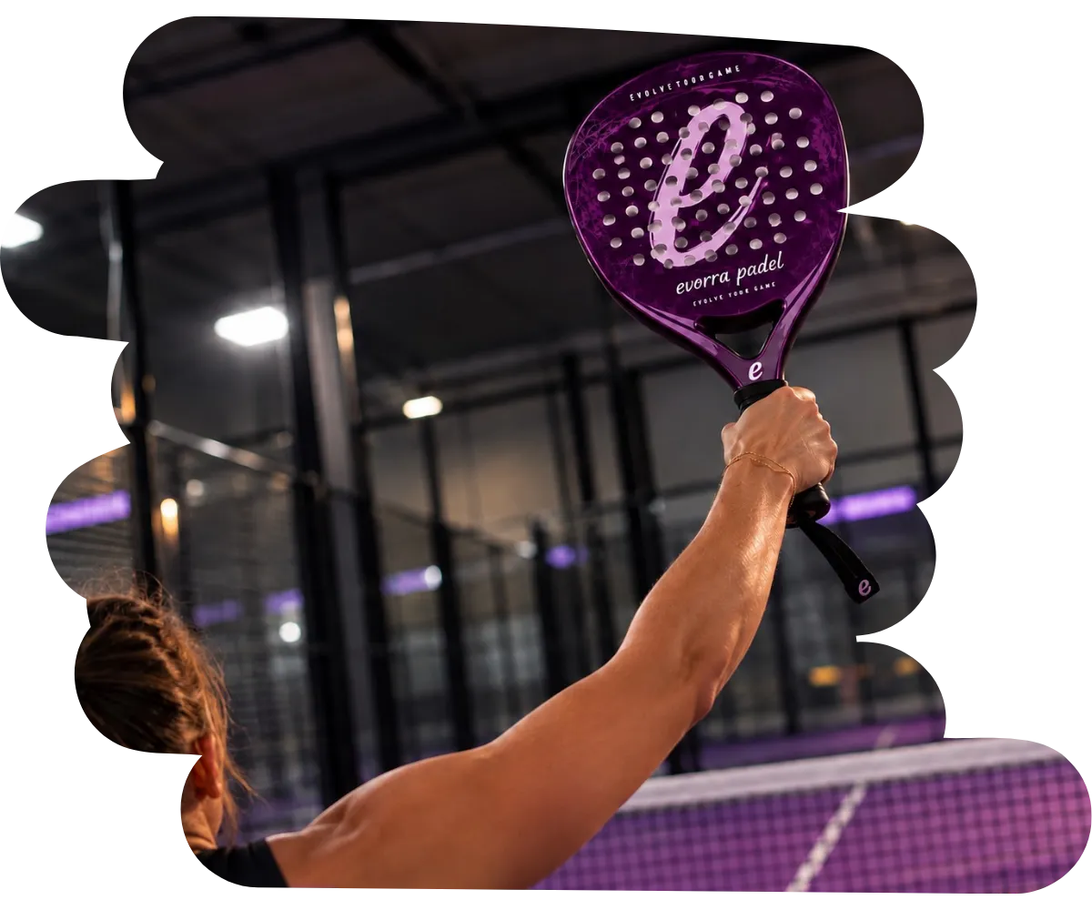 A player swinging an Evorra branded paddle on an indoor court