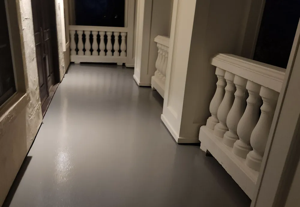 Gray coated walkway with decorative white railings at night