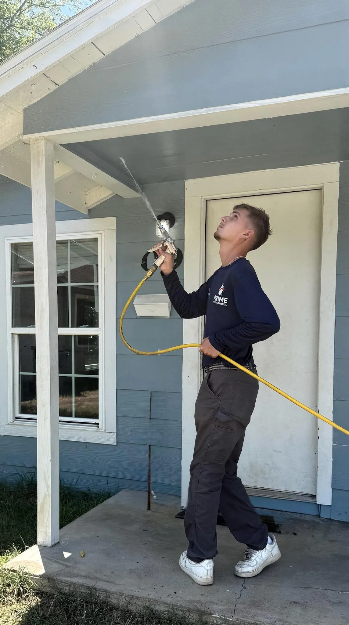 Pest control technician spraying outdoors
