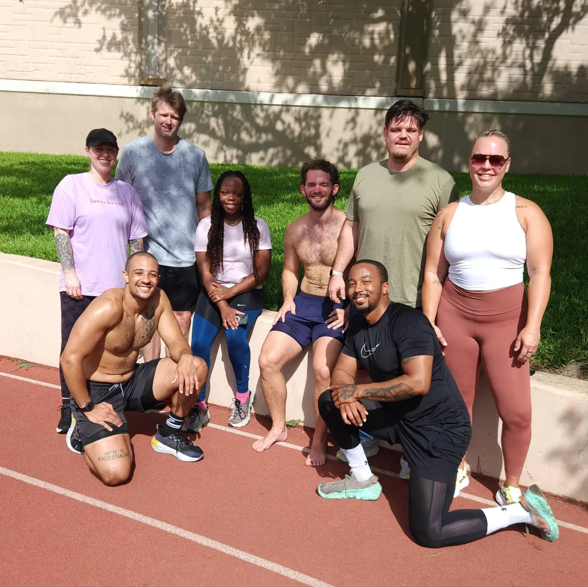 Group of fitness clients and personal trainer from Wilson Wellness Solutions enjoying a successful outdoor workout session, showcasing teamwork and personalized training in Dallas.