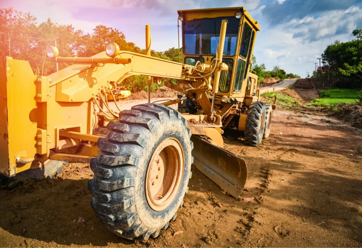Motor grader leveling an unsealed road during road construction and civil works