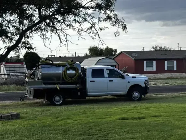 White Maddog Services septic pump truck with a vacuum tank on a flatbed.