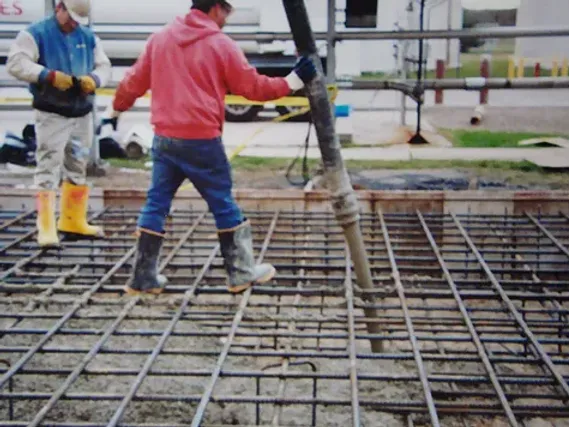 Industrial manufacturing worker walking along rebar foundation 