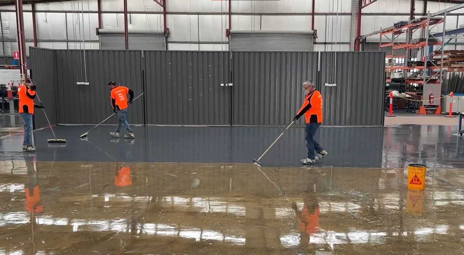 commercial warehouse with concrete being coated with grey epoxy floor