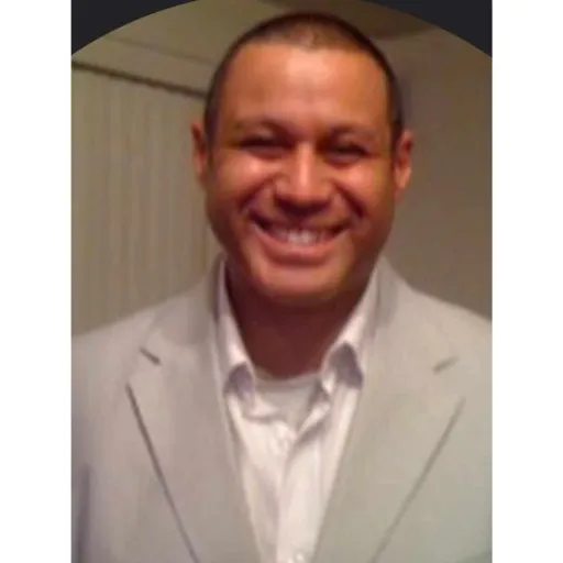 A confident, smiling real estate agent in a modern, sunlit home interior, holding a clipboard and greeting a diverse couple. The background features tasteful decor and large windows, conveying trust and professionalism. 3:2 aspect ratio.