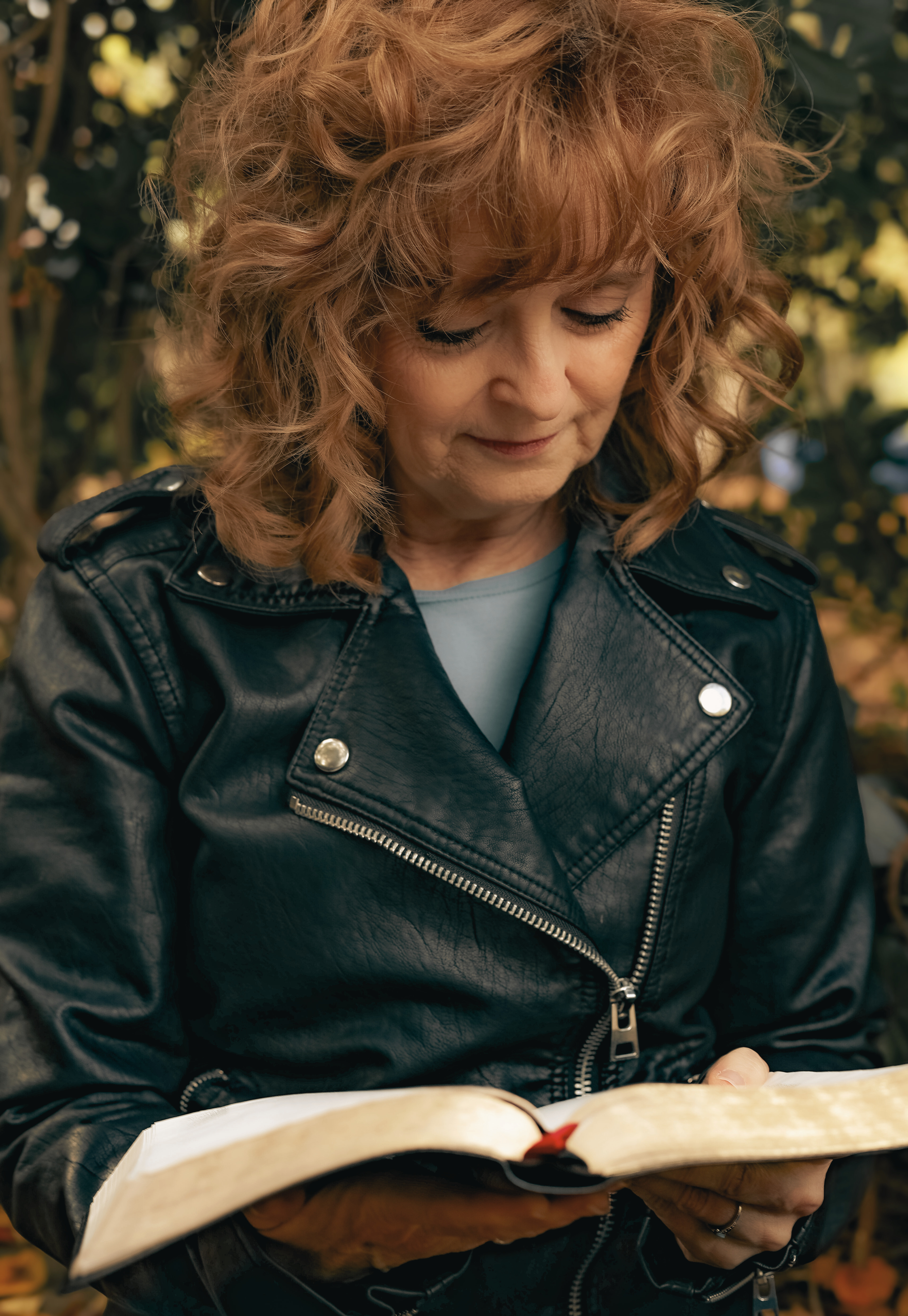 A warm outdoor photo of Rhonda reading her Bible, reflecting the heart of Rebuild Evergreen — a faith-rooted space for women rebuilding with wisdom, courage, and care after loss, change, heartbreak, or an unwanted life season.