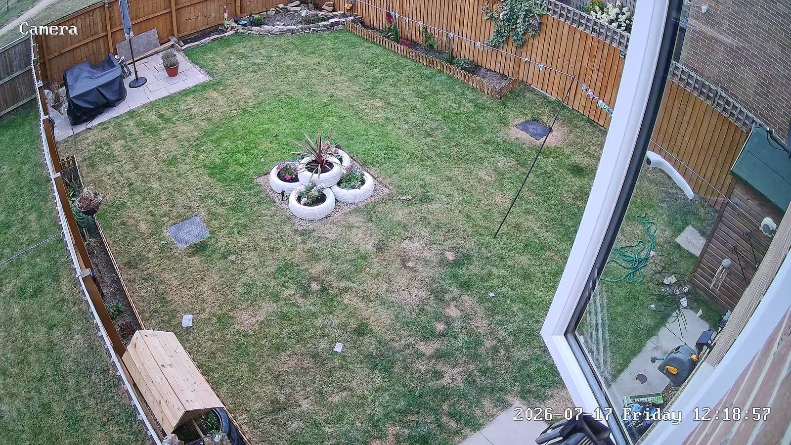 CCTV camera view of a rear garden lawn and fenced boundary, installed by L&B Security